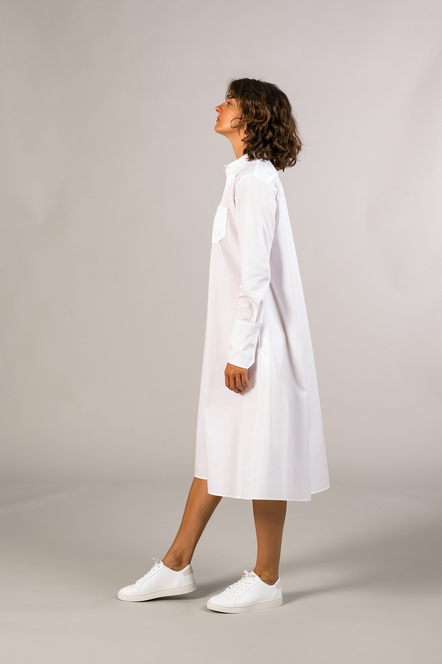 Profile of womens white tuxedo shirt dress, 100% sustainable cotton poplin from Italy, long sleeve, button down knee length.
