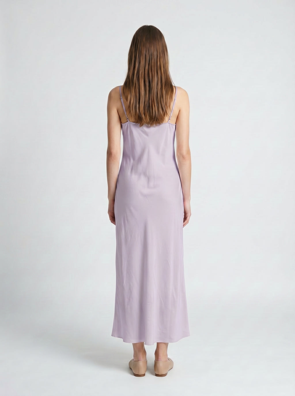 Woman wearing a light purple slip dress on a white background 