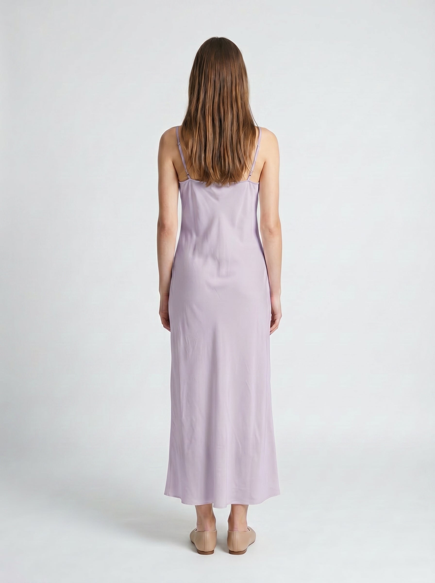 Woman wearing a light purple slip dress on a white background 