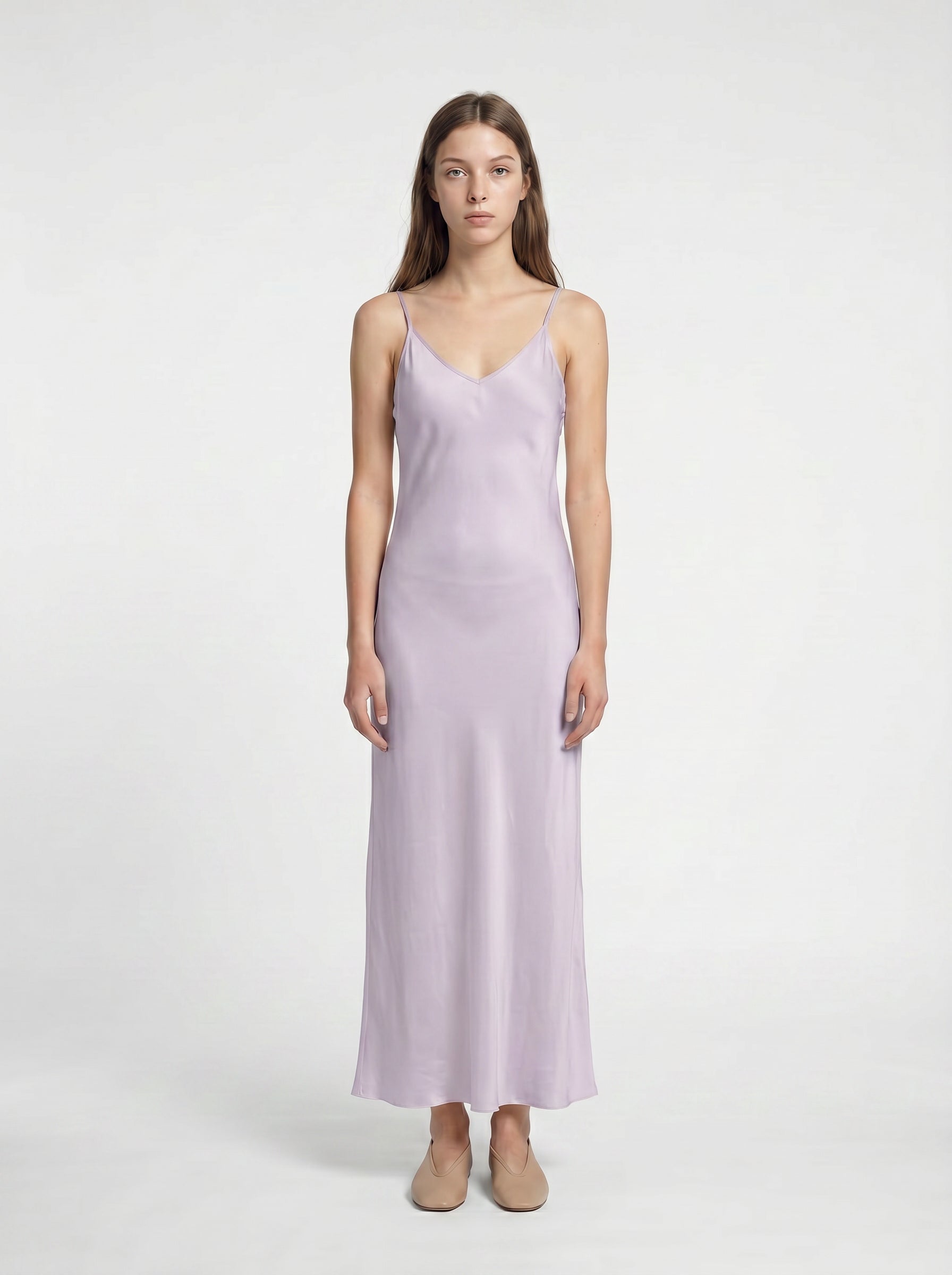 Woman wearing a light purple slip dress on a white background 