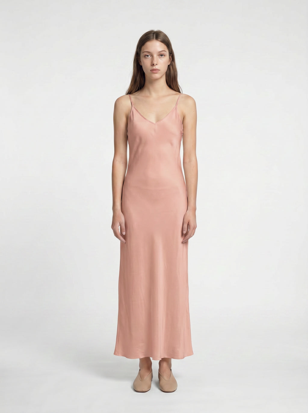Woman wearing a pink slip dress on a white background