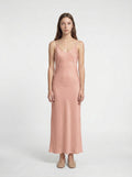 Woman wearing a pink slip dress on a white background