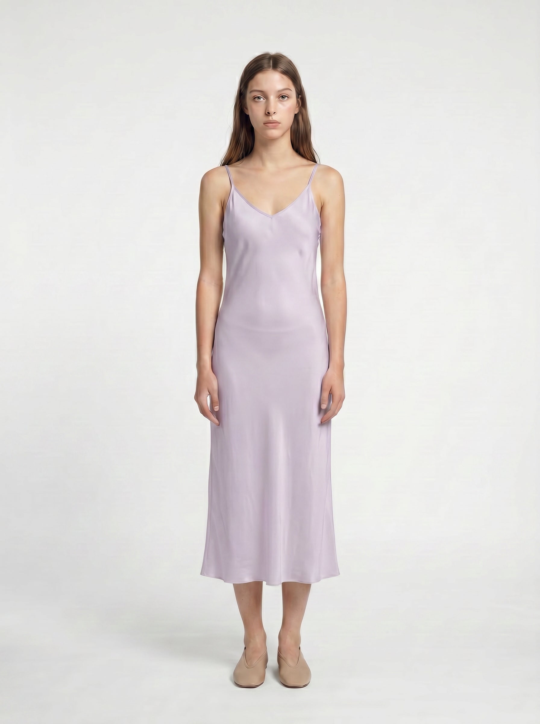 Woman wearing a light purple slip dress on a white background