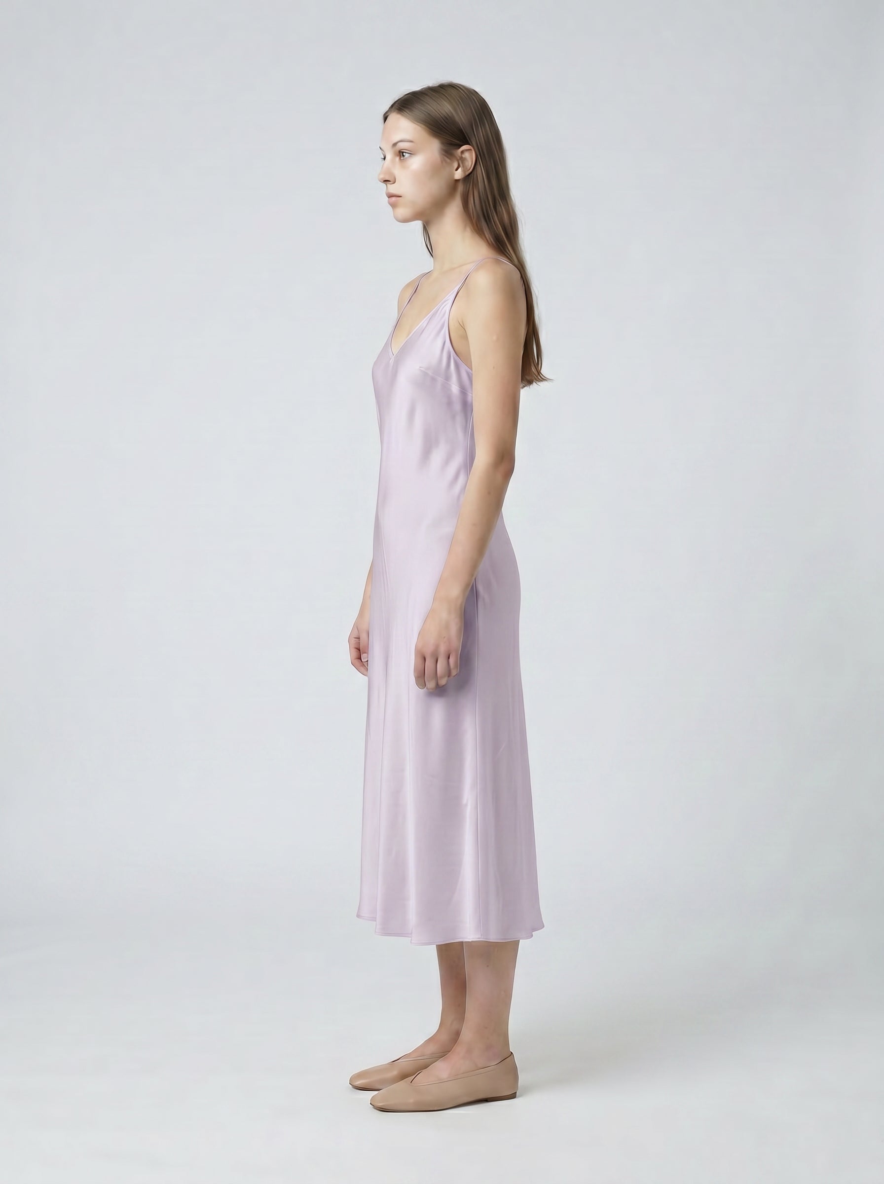 Woman wearing a light purple slip dress on a white background