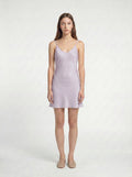 Woman wearing a light purple  mini slip dress on a white background 