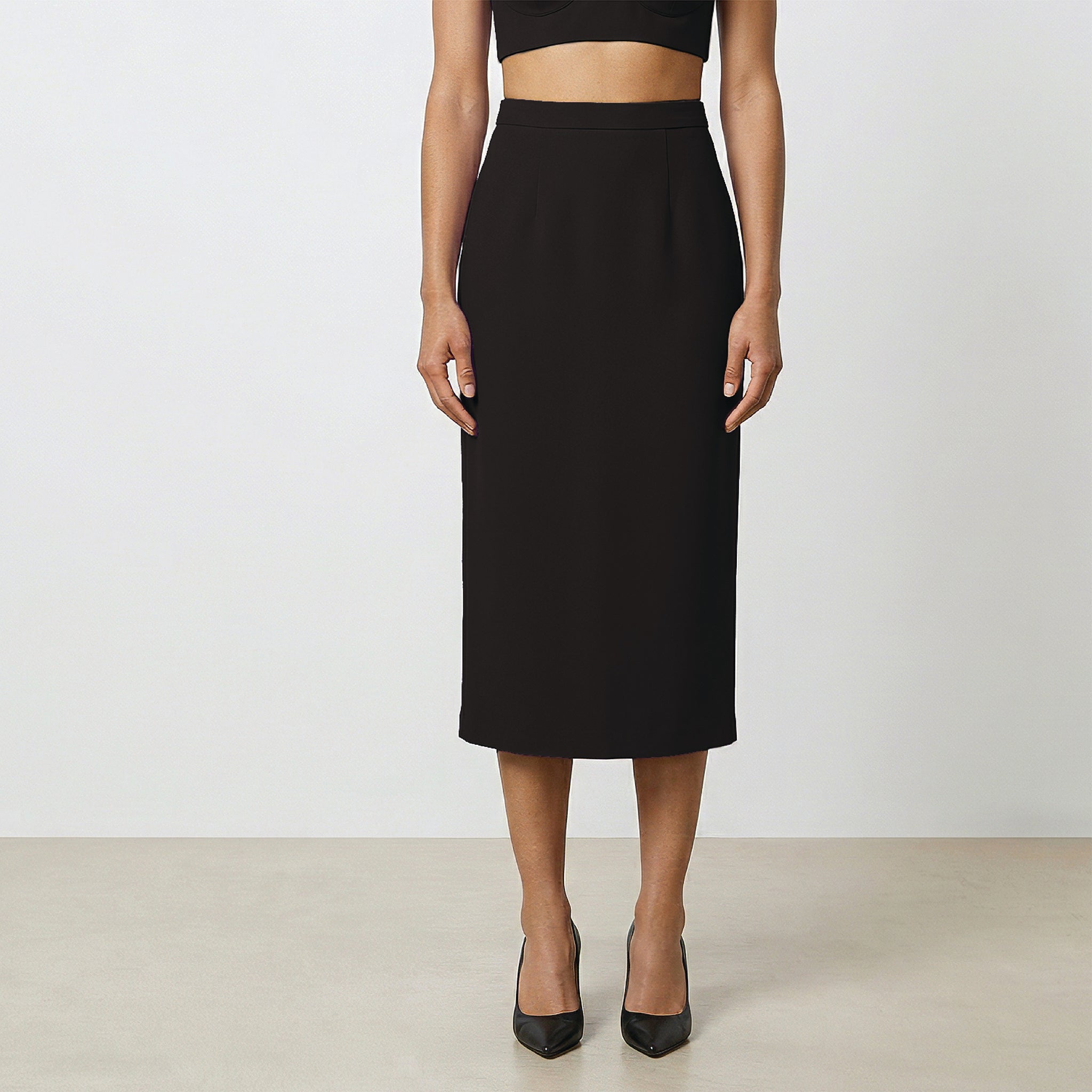 Person wearing a black skirt on a plain background