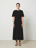 Woman wearing a black dress against a plain background front view
