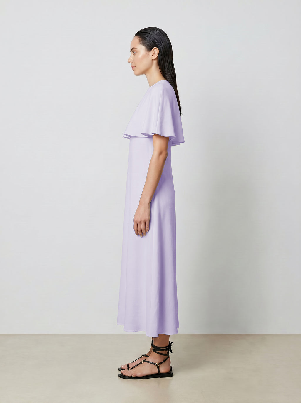 Woman wearing a light purple dress standing against a plain background