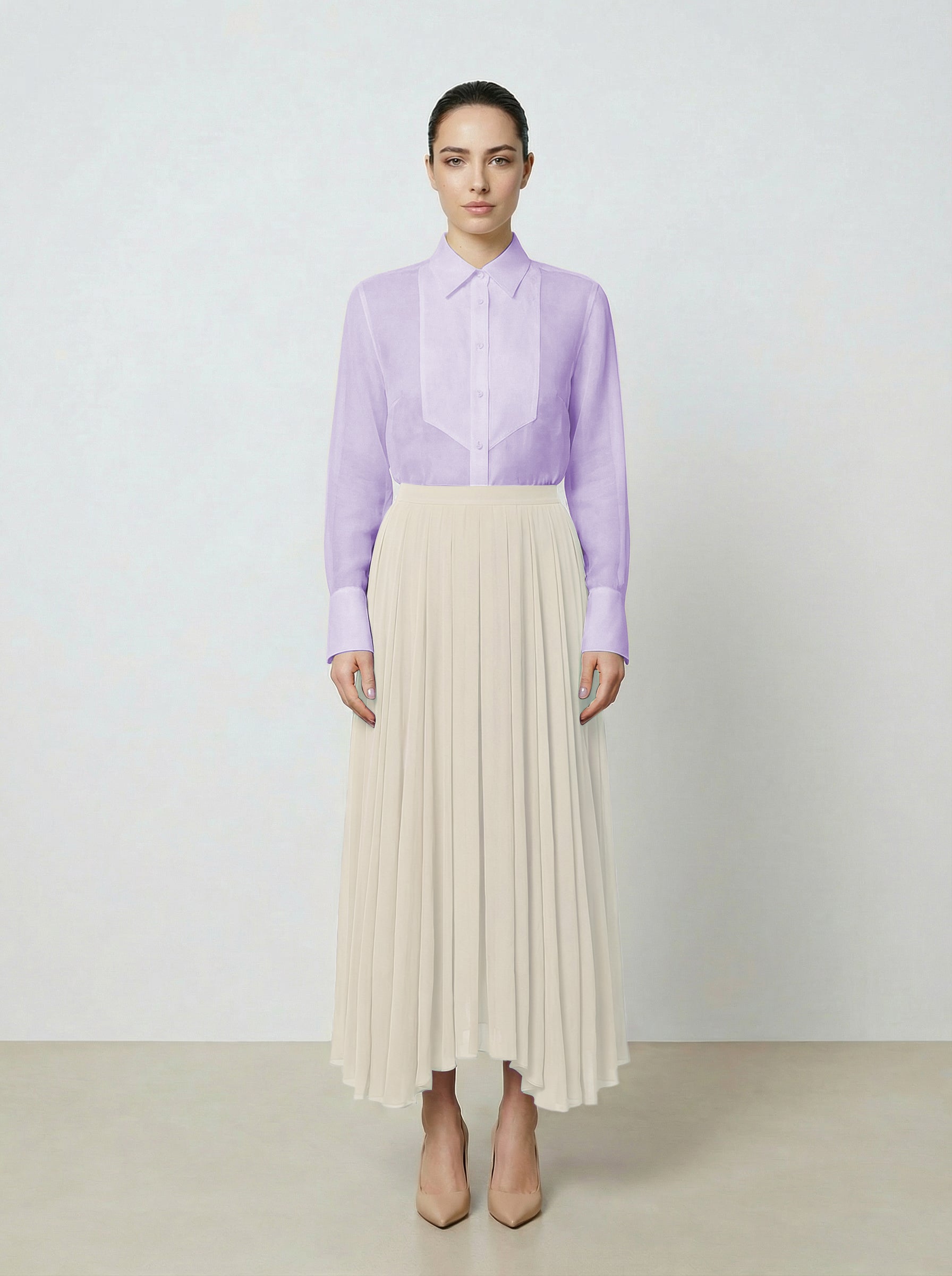 Woman wearing a light purple  translucent organza blouse and creme pleated skirt on a white background