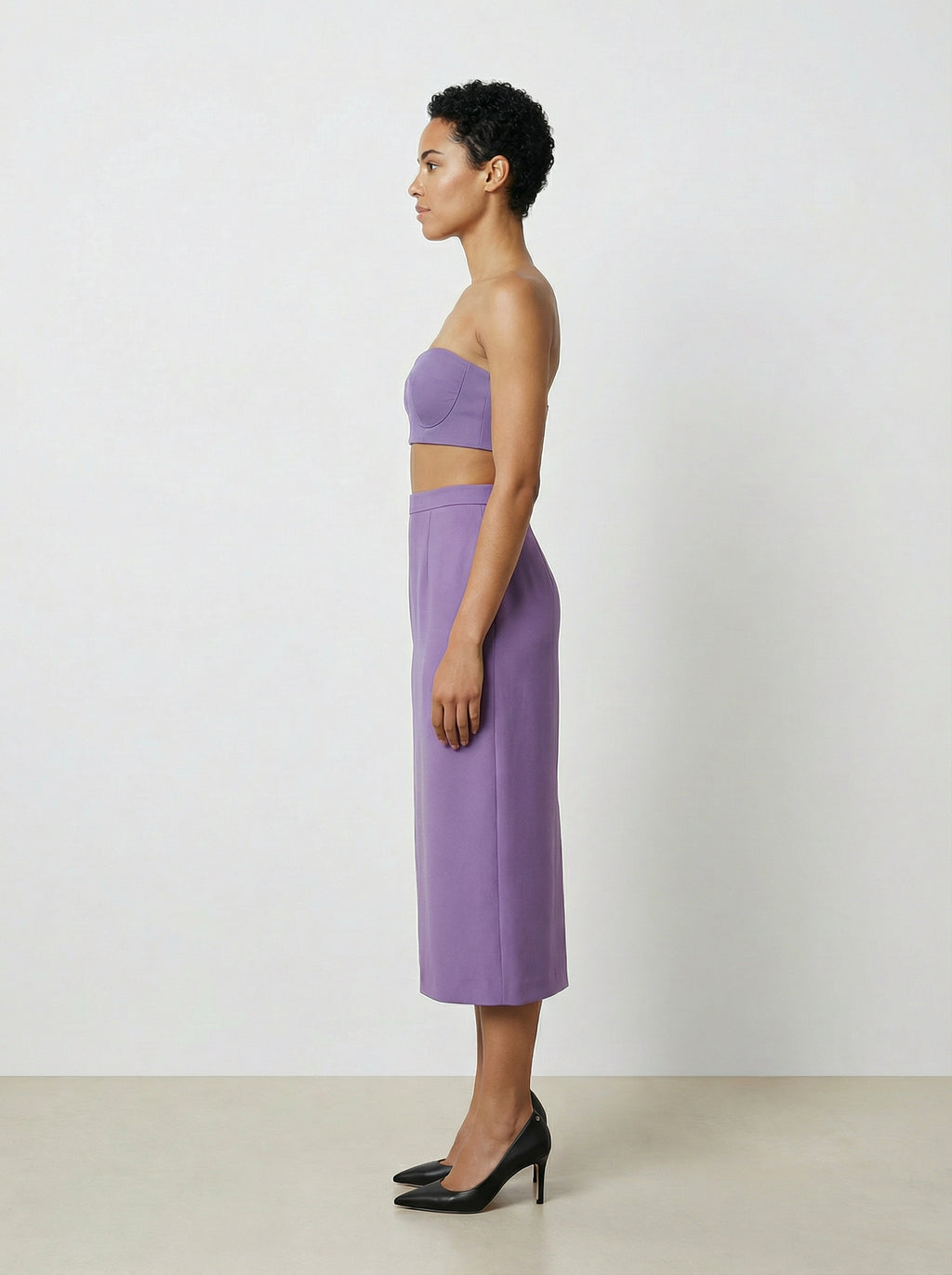 Woman wearing a purple outfit against a white background